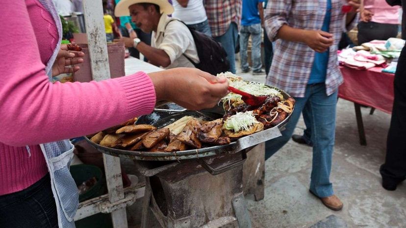 A woman prepares Mexican street food: mole enchiladas, fried tamales, fried tacos and quesadillas. Jacobo Zanella/Getty Images