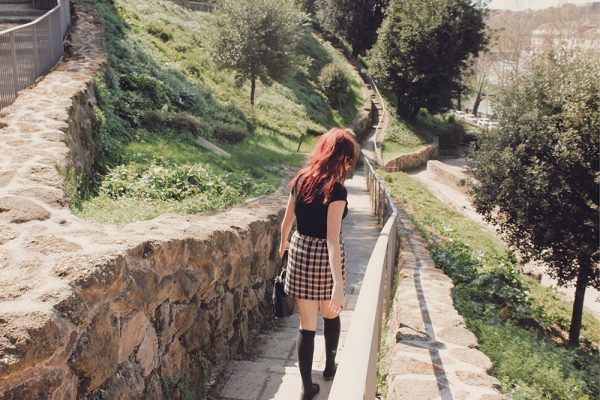 Red-headed woman climbing down stairs in Rome